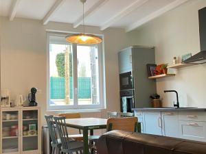 a kitchen and dining room with a table and a window at L Obione charmante maison de pêcheur rénovée proche mer avec patio extérieur in Le Tréport