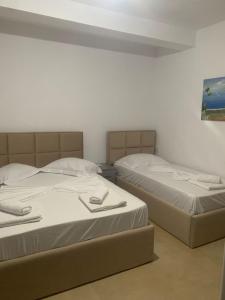 Dos camas una al lado de la otra en una habitación. en Guesthouse Sueda, en Ksamil