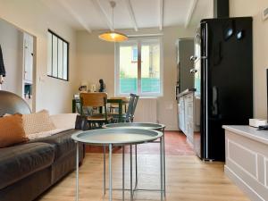 a living room with a couch and a table at L Obione charmante maison de pêcheur rénovée proche mer avec patio extérieur in Le Tréport