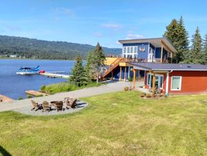 a house on the shore of a lake with chairs at Grewingk Suite - Homer Seaplane Base in Homer