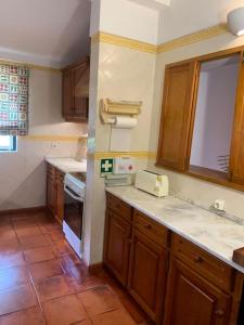 een keuken met houten kasten en witte aanrechtbladen bij The S House - Santo Estêvão in Santo Estêvão