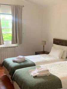 een slaapkamer met een bed met twee handdoeken erop bij The S House - Santo Estêvão in Santo Estêvão