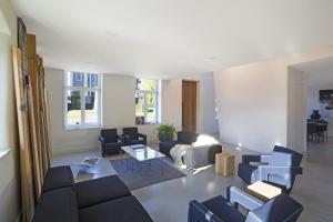 uma sala de estar com sofás e cadeiras e uma mesa em B&B Opus35 em Montzen