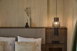 a bedroom with a bed with a vase and a lamp at Casa Tsouka ApartHotel in Fanari