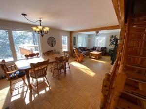 a dining room and living room with a table and chairs at Country Chalet with Lakefront in Chertsey +19 photos