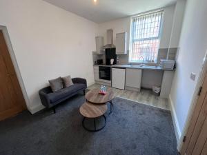 a small living room with a couch and a table at Riverside by Teil Luxurious one bed Apartment in Preston