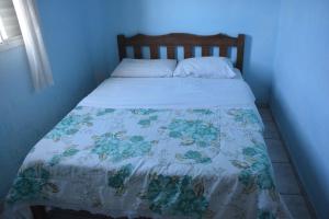 a bed in a blue room with a blanket on it at Pousada do Jackson in São Thomé das Letras