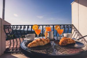 a table with croissants and orange juice on a balcony at Villa Dese in Splitska