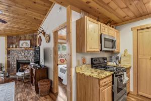 a kitchen with wooden cabinets and a stove top oven at Blowing Rock Cottage in Blowing Rock