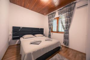 a bedroom with a large bed and a window at Villa Dese in Splitska