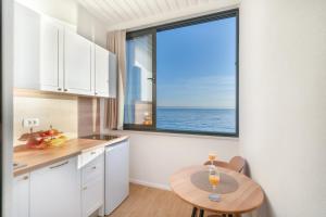 a kitchen with a table and a large window at Apartments Malina in Tučepi