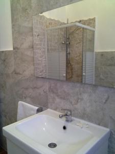 La salle de bains est pourvue d'un lavabo et d'un miroir. dans l'établissement B&B Le Betulle, à Cardano al Campo