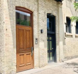 a wooden door on the side of a brick building at Modern Vintage Vibe Condo in Milwaukee