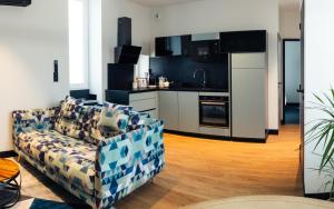 a living room with a couch and a kitchen at Gîte petite lauze in Espalion