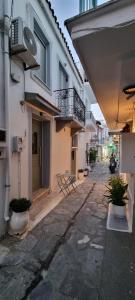 an alley between two buildings with a balcony at G-House Skiathos in Skiathos