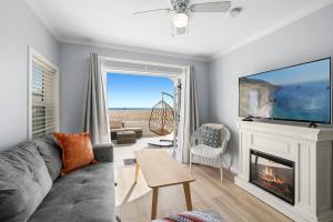 a living room with a fireplace and a tv at 1628 West Oceanfront Oasis - All Units in Newport Beach