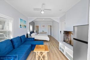 a living room with a blue couch and a bed at 1628 West Oceanfront Oasis 1,2,3 in Newport Beach