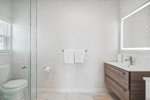 a bathroom with a toilet and a glass shower at 1628 West Oceanfront Oasis - 5,8,9 in Newport Beach +26 photos