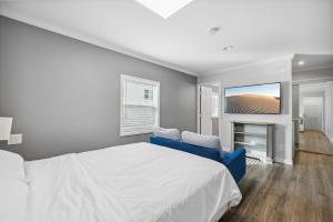a bedroom with a white bed and a blue couch at 1628 West Oceanfront Oasis 1 in Newport Beach