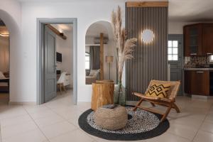Una sala de estar con una silla y una mesa. en 37 2 Heaven, en Naxos Chora