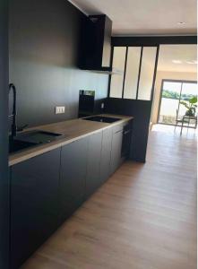 una cucina con armadi neri e pavimenti in legno di La villa Pontivyenne a Noyal-Pontivy