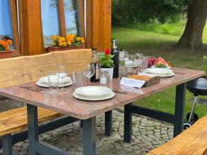 a picnic table with plates and wine glasses on it at Domek Dzika Róża in Szklarska Poręba
