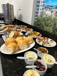 a table topped with plates of pastries and other foods at Nacional Park Hotel Lages in Lages