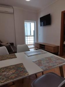 a living room with tables and chairs and a television at Glen's Apartament at Qerret Beach in Golem
