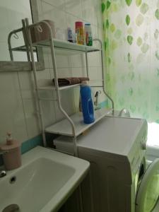 a bathroom with a sink and a toilet and a shelf at Glen's Apartament at Qerret Beach in Golem +12 photos