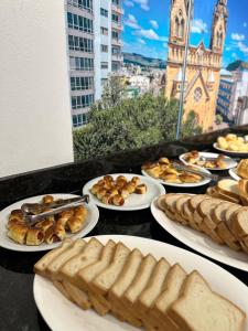a table topped with plates of bread and pastries at Nacional Park Hotel Lages in Lages