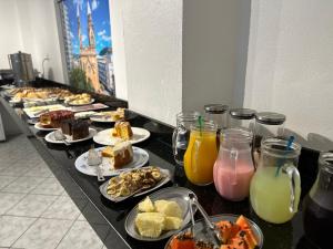 a buffet line with plates of food and drinks at Nacional Park Hotel Lages in Lages