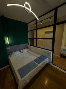 a bedroom with a bed with a green wall at Gigi Apartment by eluxory in Skopje +36 photos