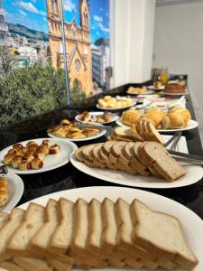 a buffet line with plates of bread and pastries at Nacional Park Hotel Lages in Lages