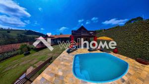 a villa with a swimming pool and a house at Chale aconchegante em Sao Bento do Sapucai in São Bento do Sapucaí