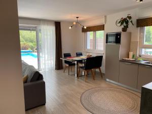 a living room with a kitchen and a table with chairs at RoyalHill Apartman in Vonyarcvashegy