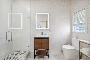 a bathroom with a shower and a sink and a toilet at West Oceanfront Oasis 4 in Newport Beach
