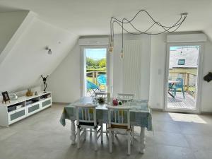 a white dining room with a table and chairs at Appartement près de la mer in Larmor-Plage