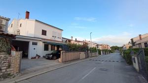 a street with houses and a car parked on the street at Apartments Alex in Rovinj