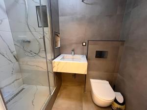 a bathroom with a shower and a toilet and a sink at Gigi Apartment by eluxory in Skopje
