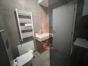 a bathroom with a white toilet and a sink at Gigi Apartment by eluxory in Skopje