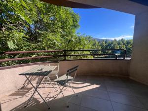 a table and two chairs sitting on a balcony at Gigi Apartment by eluxory in Skopje