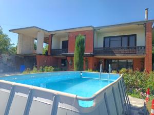 a swimming pool in front of a house at Retro House in Telavi