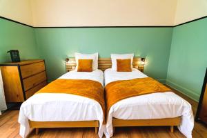 two beds sitting next to each other in a bedroom at Bel AMI 01 - Turquoise & OR - Moderne Chic - Centre Ville - Accès Jardin - Clim - Wifi - Parking - Localisation idéale in Schiltigheim