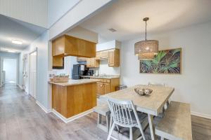 a kitchen and dining room with a table and chairs at Amelia Island Condo with Pool Access Walk to Beach! in Fernandina Beach