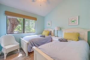a bedroom with two beds and a chair and a window at Amelia Island Condo with Pool Access Walk to Beach! in Fernandina Beach +25 photos