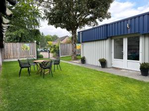 a yard with a table and chairs in the grass at Casa Delfts Blauw in Mierlo
