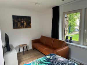 a living room with a couch and a window at Casa Delfts Blauw in Mierlo
