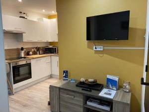 a kitchen with a flat screen tv on the wall at "Appartement sur digue" proche de la plage avec wifi in Wimereux