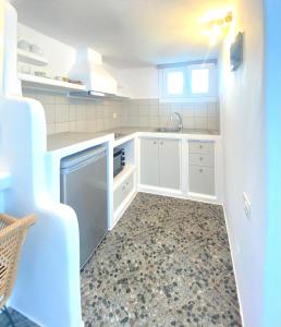 a kitchen with white cabinets and a sink at Agia Kyriaki Studios in Agia Kiriaki Beach