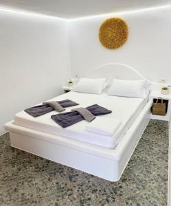 a white bed in a white room with towels on it at Agia Kyriaki Studios in Agia Kiriaki Beach